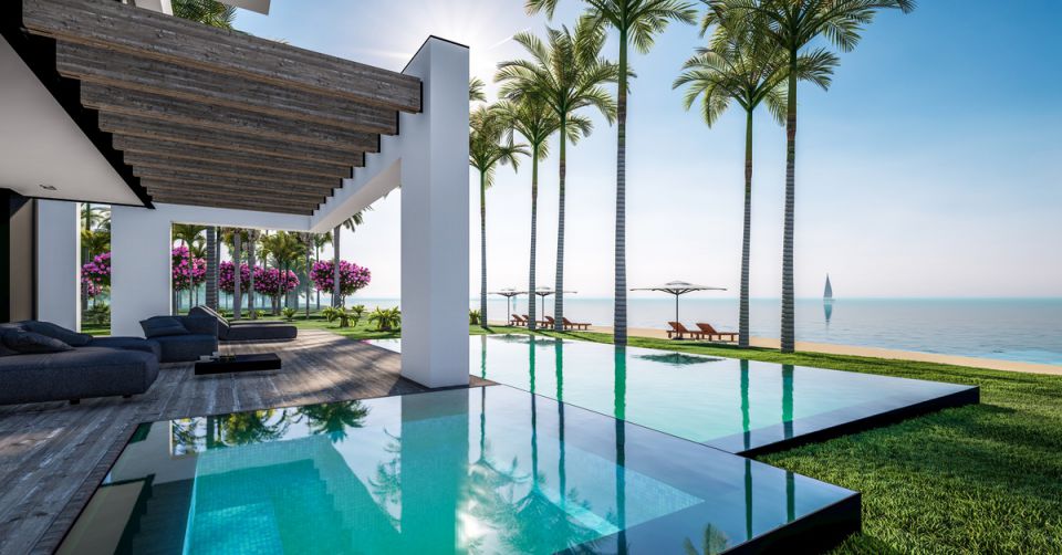 A modern luxury beach house sits on the shore, featuring a pool surrounded by palm trees, flowers, and beach chairs.